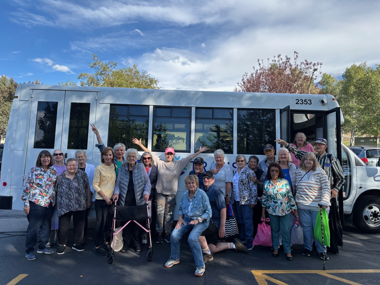 Picture of a group of senior riders next to a bus with Nancy Jo their bus operator